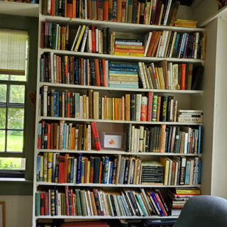 A tall shelf filled with works of fiction